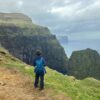 People at Búgvin sea stack