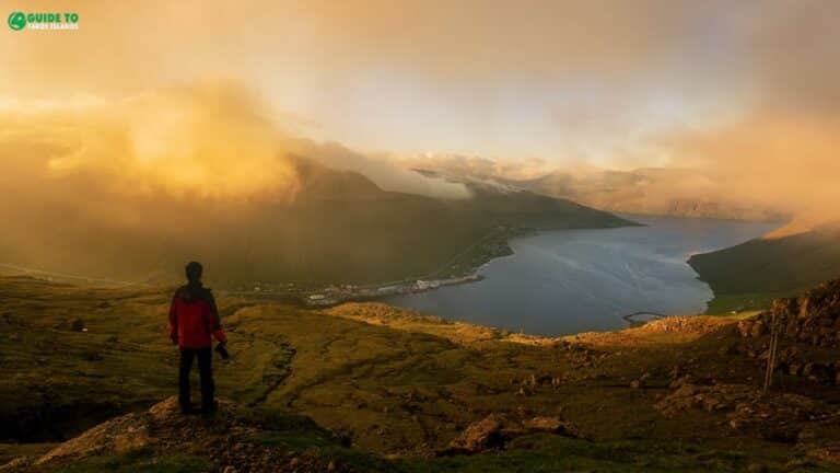 Person standing and watching fjord