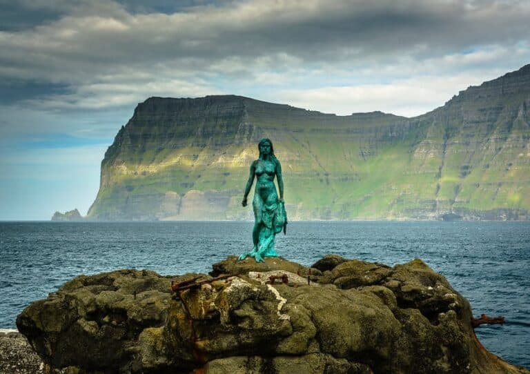Statue of lady on rock