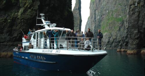 Boat sailing between sea cliffs
