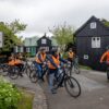 Cyclists surrounded by small houses