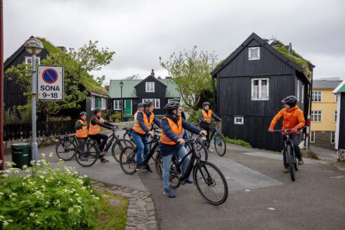 Cyclists surrounded by small houses