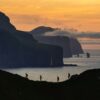 People walking on Kalsoy Island in sunset