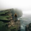 Man standing next to cliffs in the Faroe Islands