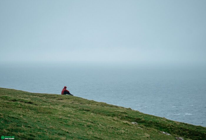 Person sitting on grassy hill