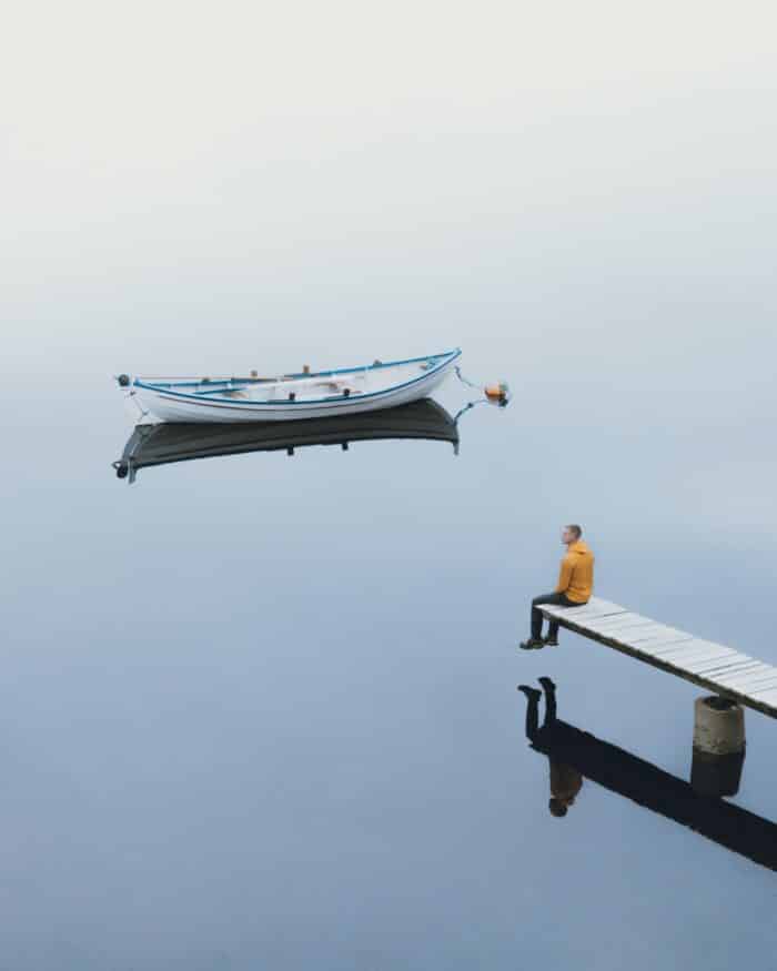 Man sitting next to boat