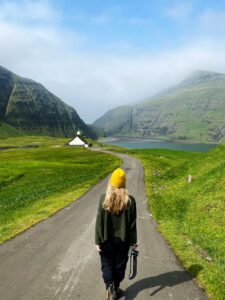 Person walking on tarred road with church nearby