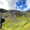Person taking photo in green valley