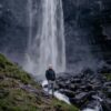 Man in front of waterfall