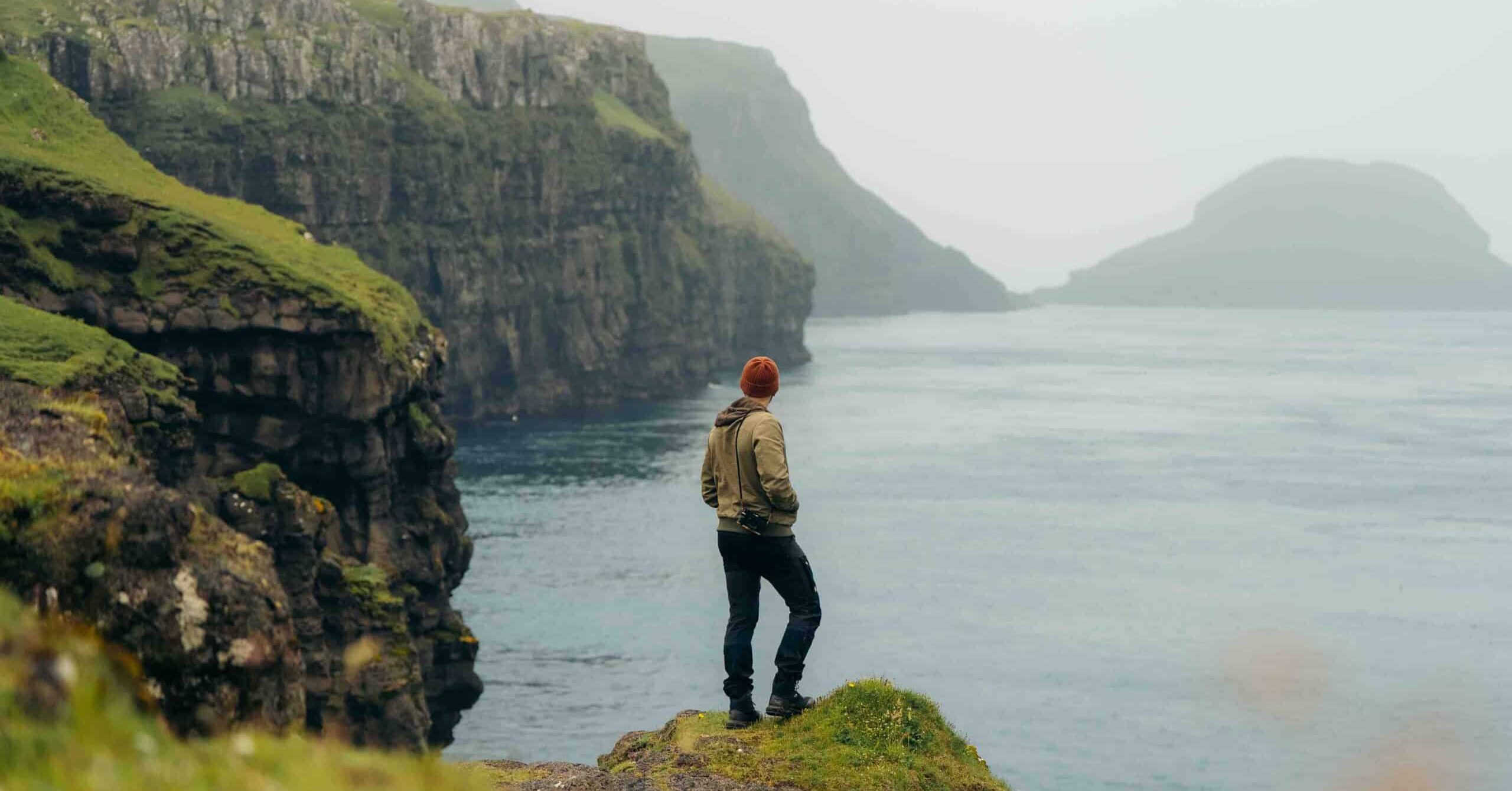 Man standing in front of cliffs